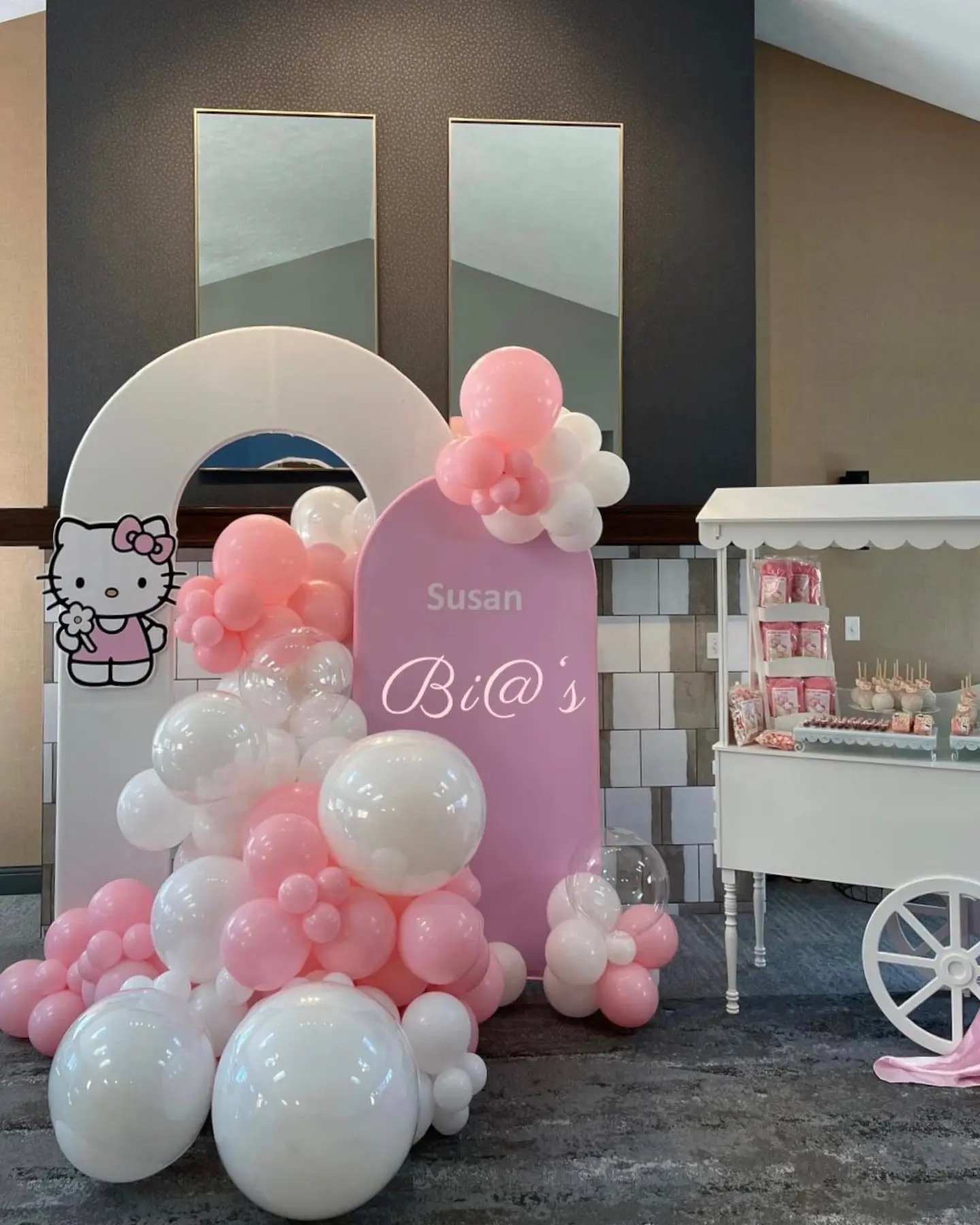 Pink balloon arch and dessert cart set up for a Lincoln party
